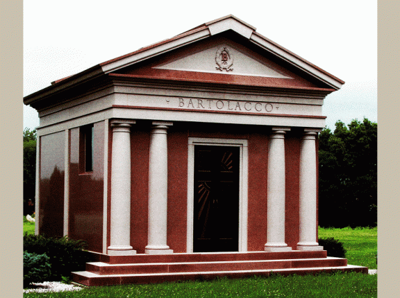 Walk-in 16 crypt private family mausoleums are for sale at Rome Monument. Pictured here is a walk-in 16 crypt private family mausoleum constructed with polished rose colored granite. It features half turned columns created in a tiffany rose finish. There is a hand tooled wreath with a polished raised family initial (B) crated on the front of the roof stone.  The family walk-in mausoleum dimensions are 18'-4" x 19'-8" x 16'-4".